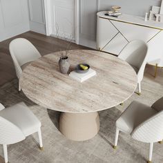 a round wooden table surrounded by white chairs