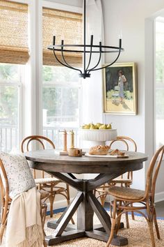 a dining room table with chairs and a chandelier hanging from it's ceiling