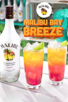 two glasses filled with drinks sitting on top of a table next to a bottle of malbu bay breeze