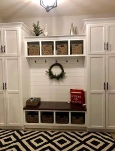 the entryway is decorated for christmas with white cabinets and black and white rugs