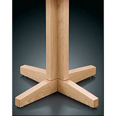 a wooden table with four legs and one leg extended to the side, on a black background