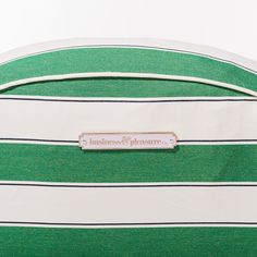 a green and white striped bag with the name business & pleasure on it's side