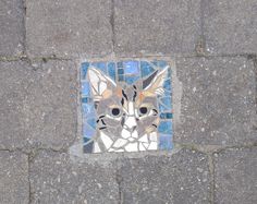 a mosaic on the ground depicting a cat's face