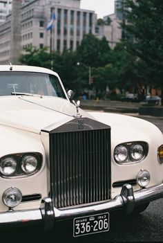 an old white car parked on the side of the road