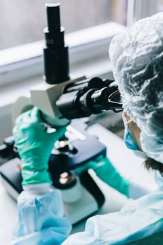 a scientist looking through a microscope at something