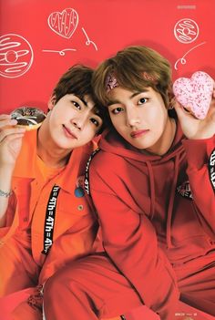 two young men sitting next to each other holding donuts