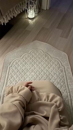 a person laying on top of a bed covered in a blanket