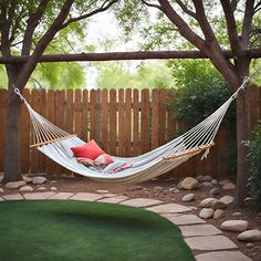 a white hammock hanging from a wooden fence