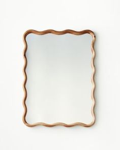 a mirror that is on the wall with some kind of frame around it's edge