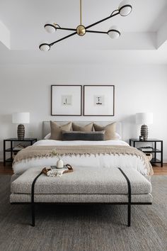 a bedroom with white walls and furniture in the corner, including a bed that has two framed pictures on the wall above it