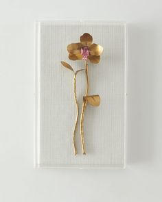 a gold brooch with a pink flower in it's center on a white background