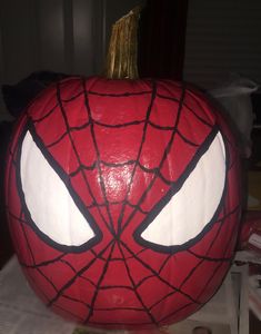 a pumpkin decorated to look like spider man