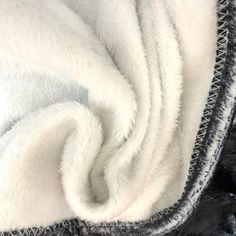 a pile of white and black blankets sitting on top of each other