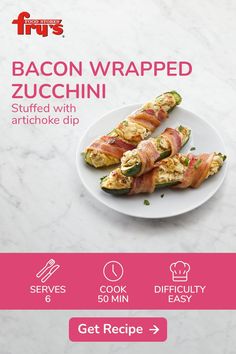 bacon wrapped zucchini stuffed with artichoke dip on a white marble countertop