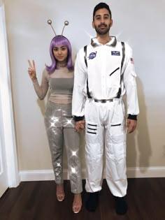 a man and woman dressed up in space suits standing next to each other on a hard wood floor