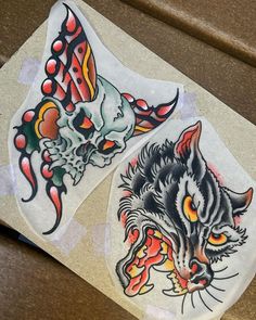 two stickers with cats and skulls on them