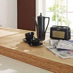 a wooden table topped with a black coffee pot