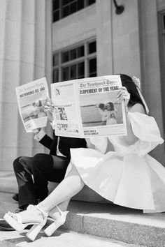 a man and woman sitting on the steps reading newspapers