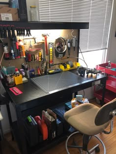 a workbench with lots of tools on it in a home office area next to a window