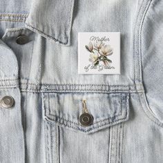 a white flower pin sitting on the back of a jean jacket