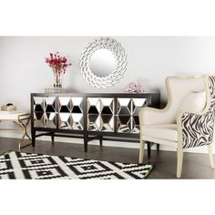 a living room with zebra print rugs and mirrors on the wall, along with two chairs