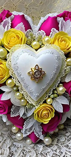 a heart shaped box with flowers and pearls