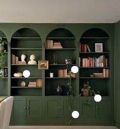 a room with green walls and built in bookshelves