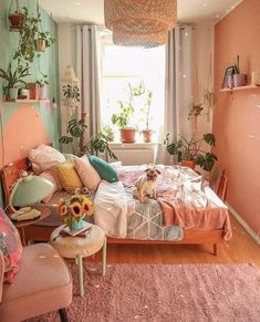 a bedroom with pink walls and lots of plants