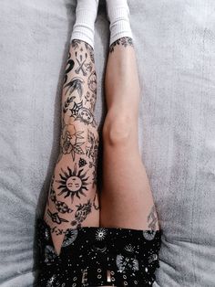 a person with tattoos laying on a bed