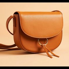 This Purse Is Made With Real Leather. It Has An Adjustable Strap, Magnetic Snap Closure, And A Zippered Inner Pocket, Too. Love The Simple Lines, The Carmel Color, And The Gold Ring Accent. (It Measures 6.5 Inches Tall, 8.25 Inches Wide, And 2.5 Inches Deep) Winter Bags, Popular Handbags, Tan Bag, Handbags Affordable, Cheap Handbags, Cheap Bags, Genuine Leather Handbag, Cute Purses, Brown Bags