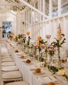 a long table with many vases filled with flowers