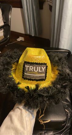 a yellow hat with the word truly on it