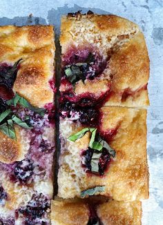 four slices of blueberry danish bread on a piece of parchment paper with fresh herbs