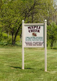 a sign that is in the grass by some trees