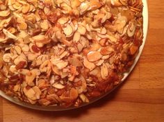 a pizza covered in nuts sitting on top of a wooden table