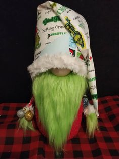 a green and white elf hat sitting on top of a red checkered table cloth