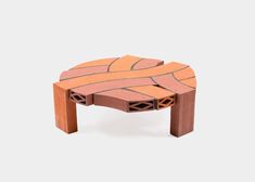 a small table made out of bricks on top of a white surface with an orange and red design