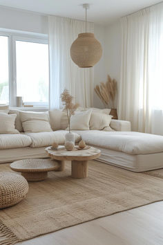 a living room filled with lots of white furniture and pillows on top of a rug