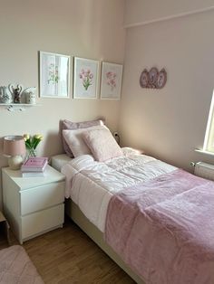 a bedroom with a bed, nightstand and pictures on the wall