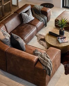 a living room with couches, tables and rugs on the floor in front of a window