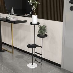 a potted plant sitting on top of a metal stand next to a table with a candle