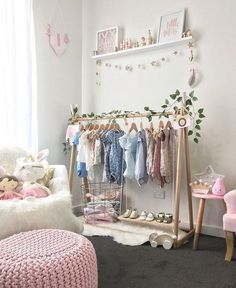 a baby's room with clothes and toys hanging on the rack in front of it