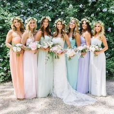 a group of women in dresses standing next to each other with flowers on their heads