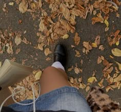 a person wearing black shoes and white socks is reading a book while sitting on the ground