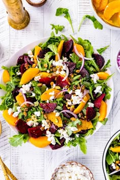 a salad with beets, oranges and feta cheese on it next to other dishes