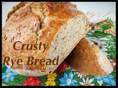 a loaf of rye bread sitting on top of a colorful table cloth with the words crusty rye bread