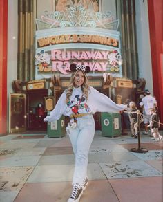 the woman is posing in front of the entrance to mickey's runaway tea - way