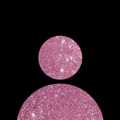 two pink glitter circles on a black background