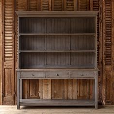 an old wooden bookcase with drawers and shutters