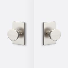 two white door knobs on the side of a wall